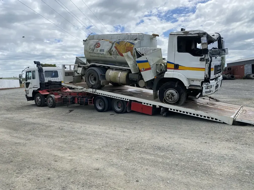 Fuel tanker truck recovered onto a heavy transporter